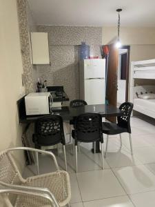 a kitchen with a table and chairs and a refrigerator at Flat Manaira, lado do Manaira Shopping in João Pessoa