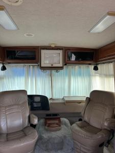 a living room with two chairs and a tv in an rv at Comfortable and cozy RV in Lehigh Acres