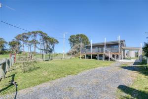 a house on a hill with a field in front of it at Lees Dream in Venus Bay
