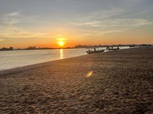 een boot aan de kust van een strand bij zonsondergang bij Tena Guest House in Don Det