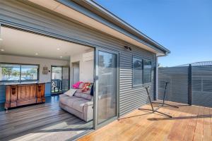 a living room with a couch on a deck at Lees Dream in Venus Bay +7 photos