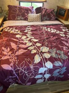 a bed with a purple comforter and pillows at Comfortable and cozy RV in Lehigh Acres