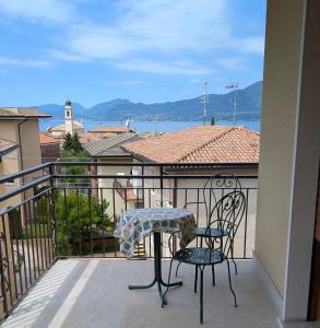 a table and chairs on a balcony with a view at Apartment with great views on Lake Garda in Torri del Benaco