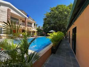 a swimming pool with plants next to a building at Monkey Republic Kampot in Kampot