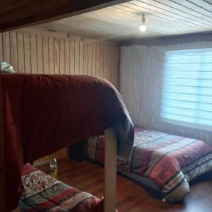 a bedroom with two bunk beds and a window at HOSTAL CARHUELLO in Pucón