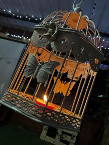 a bird cage with a bird inside of it at The Magical Garden in Cali
