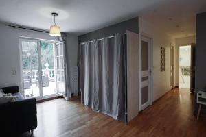 a living room with a wall with curtains on it at Villa Mandalika in Noisy-le-Grand