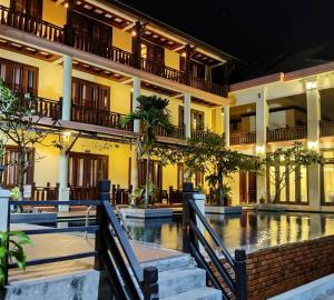 a building with a pool in front of it at Pon Arena Hotel in Muang Không