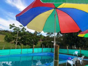 a colorful umbrella sitting next to a swimming pool at ecohostal namaste in Salento
