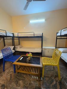 a room with a table and chairs and bunk beds at Healing Home Unity Thilo Guest House in Puducherry