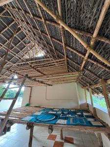 a bed in a room with a straw ceiling at Healing Home Unity Thilo Guest House in Puducherry
