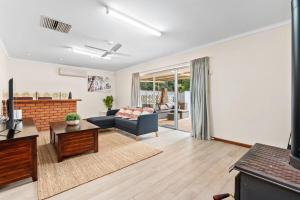 a living room with a couch and a table at Holiday house in Roleystone
