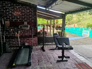 a gym with two chairs on a brick wall at ecohostal namaste in Salento