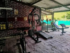 a gym with a brick wall and several tread machines at ecohostal namaste in Salento