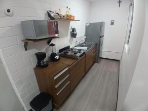 a small kitchen with a stove and a refrigerator at Depa Risalud! in Santa Cruz Huatulco +13 photos