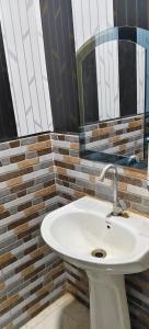 a bathroom with a white sink and a mirror at Shanti palace and restaurant Ayodhya 1500 mtr Sri Ram Mandir ,near ayodhya dham railway station in Ayodhya +38 photos