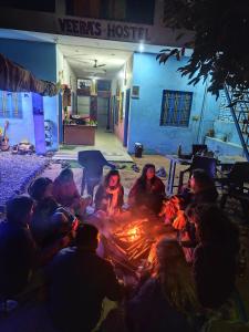 een groep mensen die rond een vuur zitten bij Veera's Hostel in Pushkar