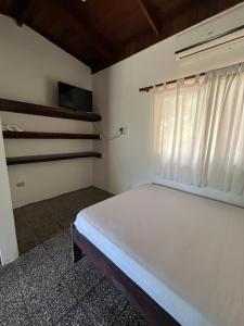 a bedroom with a white bed and a window at Her Waves & Wi-Fi Boutique Hotel in Tamarindo +10 photos