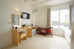 a hotel room with a desk and a mirror at Ngoc Nguyen Anh Hotel Da Lat in Da Lat +108 photos