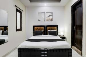 a bedroom with a large bed with white walls at Hotel O Metro Residency in New Delhi
