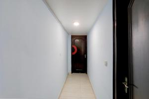 a hallway with a door and a room with a tile floor at Hotel O Metro Residency in New Delhi