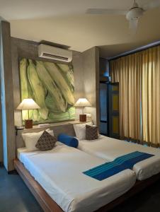 two beds in a bedroom with a painting on the wall at Sigiriana Resort by Thilanka in Dambulla +64 photos