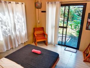 a room with a bed and a chair and a window at Playa de Bombora Inn in Cabugao