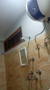 a bathroom with a sink with a light and a mirror at K2k homestsy in Rhenok