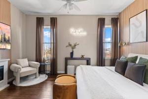 a bedroom with a bed and a chair and a fireplace at The Bricklight | Elevated 3BR + Parking in Soulard in Saint Louis