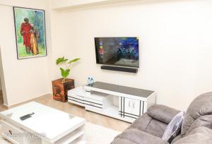 a living room with a tv on a wall at Mupa Luxury Condo IV BnB in Nyahururu