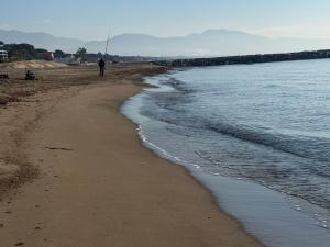 a man walking on a beach next to the water at Villa Giuseppe Seaside in Lido Di Fondi