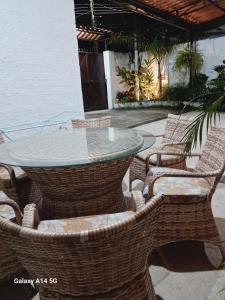 a patio with a table and wicker chairs at Recanto das Neves in Miguel Pereira