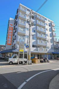 a large white building with cars parked in front of it at ゲストハウス夢宿 in Osaka