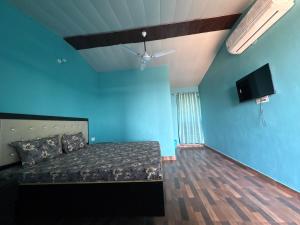 a bedroom with a bed and a blue wall at Rudraksh Hotel and restaurant in Amgarhi