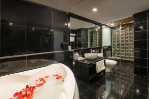 河内Ja Cosmo Hotel and Spa的黑色浴室设有浴缸和卫生间。 更多45张照片
