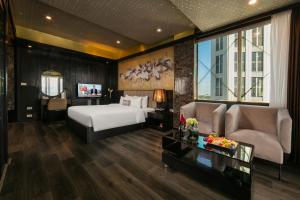 河内Ja Cosmo Hotel and Spa的一间卧室，里面有一张床、一张沙发和一张桌子