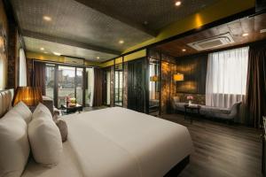 河内Ja Cosmo Hotel and Spa的一间带一张白色大床的卧室和一间客厅