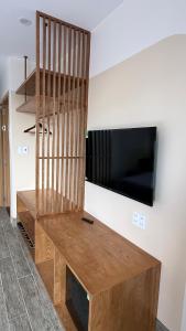 a living room with a tv and a wooden bench at Moon Hotel Buôn Hồ in Buôn Tring