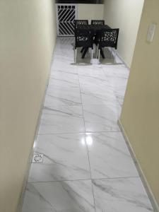 a hallway with a tile floor with a table and chairs at Casa de Maria Praia Suape in Cabo de Santo Agostinho +2 photos