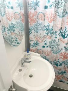 een badkamer met een wastafel en een douchegordijn bij Peace and Quiet Dorm Rooms - in Miami