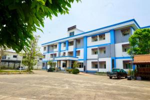 a blue and white building with a parking lot at PK Garden Hotel in Ban Chiang Wang