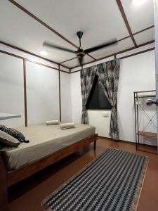 a bedroom with a bed with a ceiling fan at Scuba Buddy Mabul Dive Lodge in Pulau Mabul  +19 photos