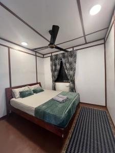 a bedroom with a bed with a ceiling fan at Scuba Buddy Mabul Dive Lodge in Pulau Mabul 