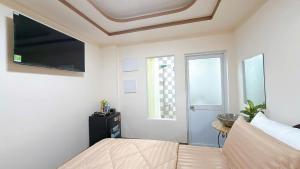 a bedroom with a bed and a tv and a window at North House in Ấp Bình Trung