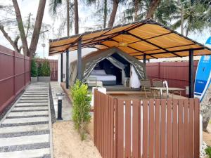 a tent with a table and chairs under it at Sichon Glamping Resort, Beachfront in Ban Plai Thon