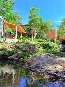 a house with a pond in front of it at Lanta Forest Resort & Villas in Ko Lanta Yai