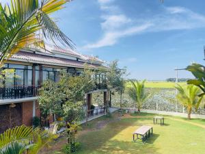a house with a picnic table in the yard at The Sanctuary Homestay in Phumĭ Don Téav