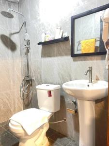a bathroom with a toilet and a sink at The Sanctuary Homestay in Phumĭ Don Téav