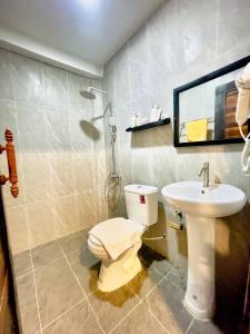 a bathroom with a toilet and a sink at The Sanctuary Homestay in Phumĭ Don Téav