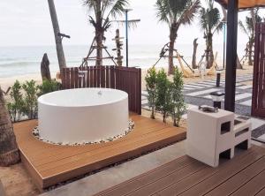 a bath tub on a deck next to the beach at Sichon Glamping Resort, Beachfront in Ban Plai Thon